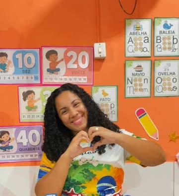 Professora do Colégio Único fazendo um coração com as mãos na sala de aula